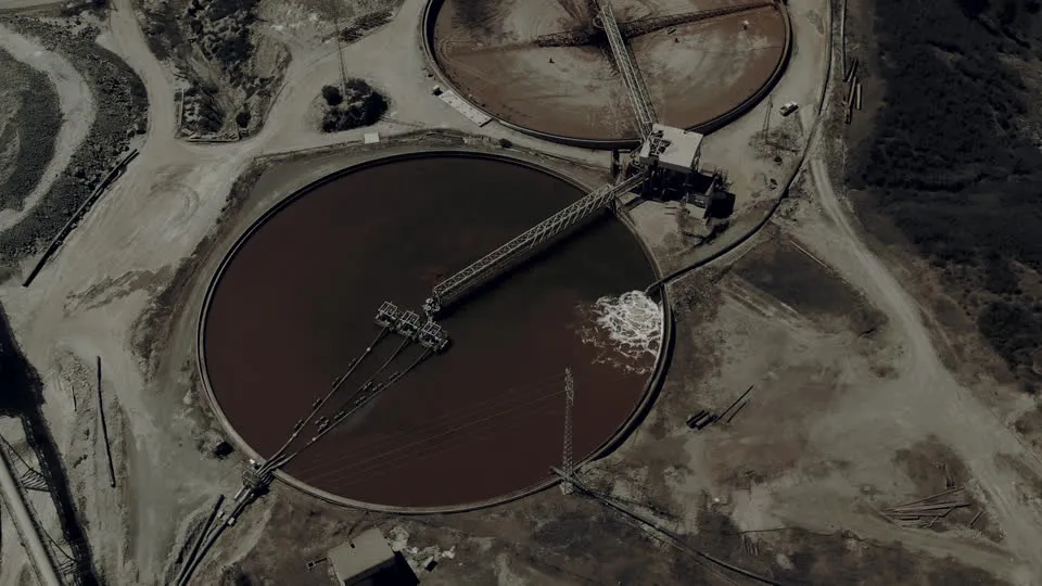 Aerial view of turbid, sediment-laden clarifier ponds: untreated industrial wastewater